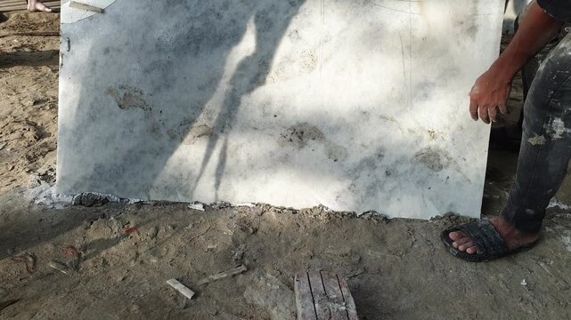 Construction Workers Installing Large White Marble Tile Slab Outdoor