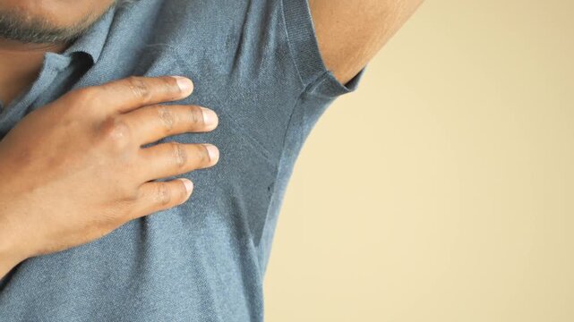 Man showing sweaty underarm in blue polo shirt with skin close-up footage