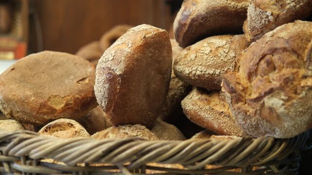 Freshly baked artisan bread in woven basket slow motion