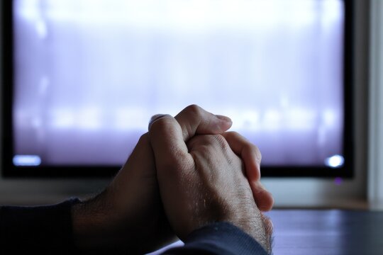 Hands clasped together in front of a glowing computer monitor symbolizing partnership and digital su