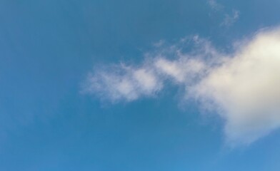 Obraz premium Clear blue sky with wispy white clouds during daytime in a soft focus scenic nature background