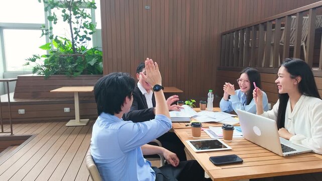 Asian Business Team Celebrating Success with High Fives on Office Terrace