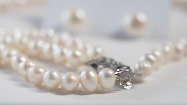 A close up view of a beautiful pearl necklace and earrings on a white background, showcasing luxurious jewelry with natural luster and elegant design