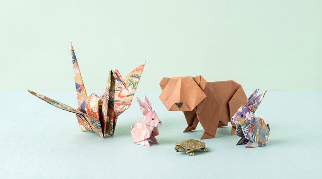 Origami animal figures, including a crane, rabbit, bear, and turtle, are arranged on a light blue background