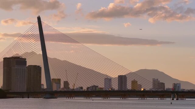 Close Up of Tran Thi Ly Bridge Cables at Sunset and flying plane in the background