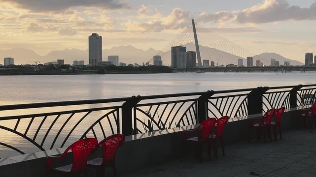 Riverside Promenade with Empty plastic chairs and View of Tran Thi Ly Bridge at Sunset