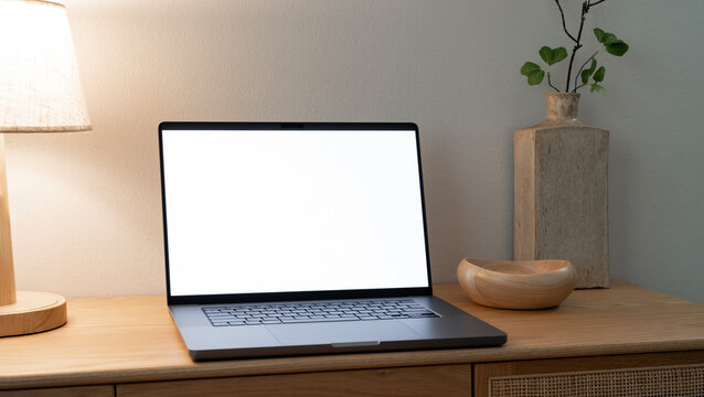 Laptop with blank screen on wooden table in cozy room mockup