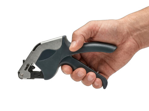 Hand holding a manual price label gun isolated on a white background