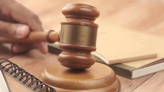 Gavel striking sound block in courtroom during legal proceedings