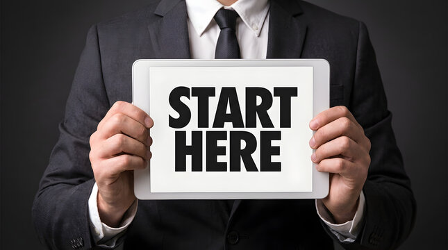 Businessman holding a tablet with the text start here on the screen with information