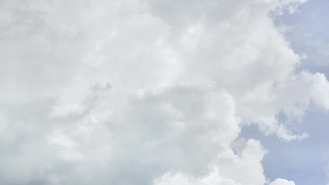 Time lapse of Vertical view of dramatic white cumulus clouds building up against soft blue sky, atmospheric overcast sky texture, vertical mobile background format, fluffy cloud formation