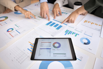 Close up business professional hands pointing at statistical documents and tablet with charts and graphs representing digital and paper analytics data interpretation and modern project development © fizkes
