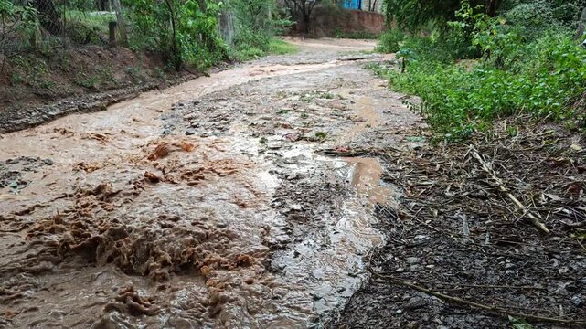 Raindrops Falling and Rippling on Muddy Dirty Water in Ravine