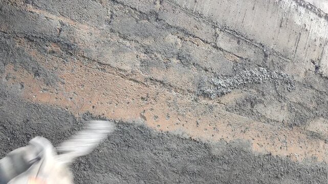 Gloved Hand Throwing Wet Cement Mortar Against Old Wall for Plastering