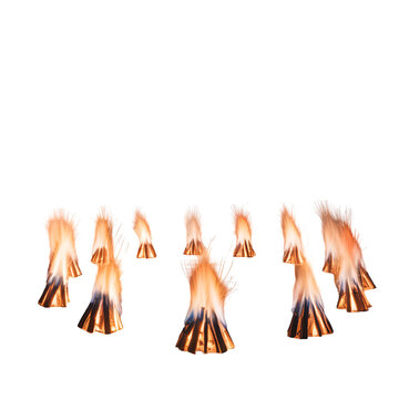Multiple small orange fire flames burning in a circle pattern on a dark ground surface area isolated on transparent background