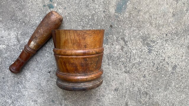 Traditional Old Wooden Mortar and Pestle on Gray Concrete Floor Background Top View