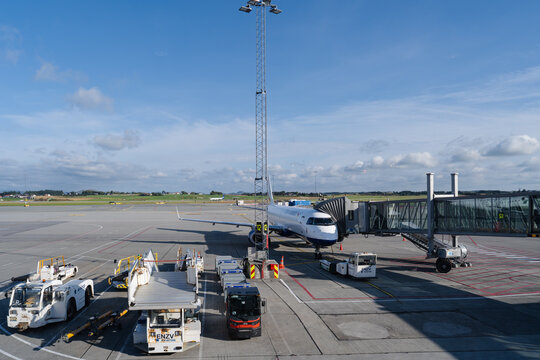 August 20, 2026, Stavanger, Norway - Wider&oslash;e Embraer E-Jet aircraft parked at a gate with a jet bridge and ground support equipment at Stavanger Airport
