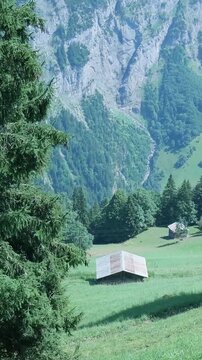Scenic alpine valley with rustic wooden huts