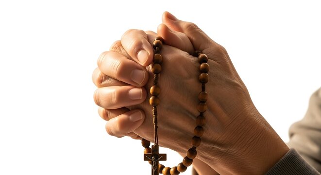 Hands praying with rosary beads during quiet devotion against a bright white background
