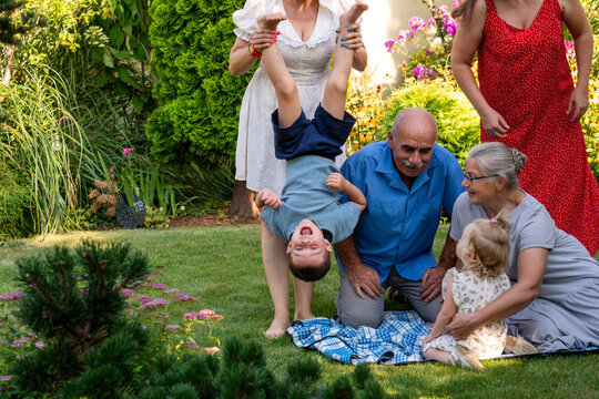 Extended Family Playing With Children During Garden Gathering