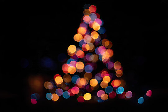 Christmas tree multicolored bokeh on dark background. Defocused multi colored lights. New Year, Christmas background, abstract texture. 