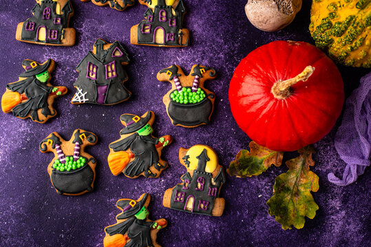 Spooky Halloween cookies shaped like witch cauldron and haunted manor
