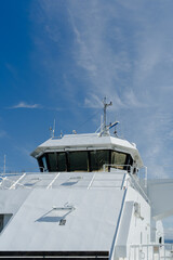 Modern white ferry bridge and navigation equipment against a clear blue sky in Norway © heerim studio