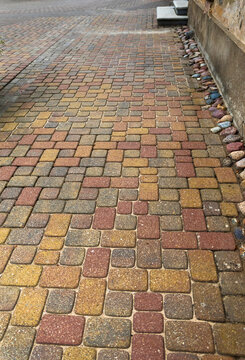 Rainy cobblestone pavement beside historic Kuldiga building