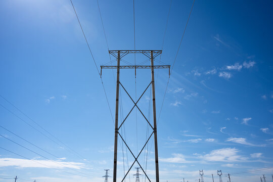 Transmission tower against blue sky and white clouds