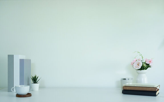 Minimal empty workspace arranged with books, flowers, and copy space.