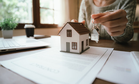 A real estate professional reviews and signs a property agreement, representing a home purchase, mortgage approval, investment, and legal transaction.