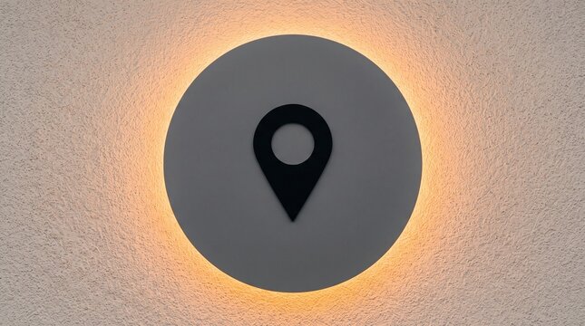 Round illuminated wall sign featuring a dark location pin symbol for modern navigation and map wayfinding concepts in a minimalist interior design