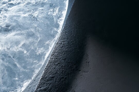 Close view of ocean waves meeting rocky shore at an unknown beach during daytime