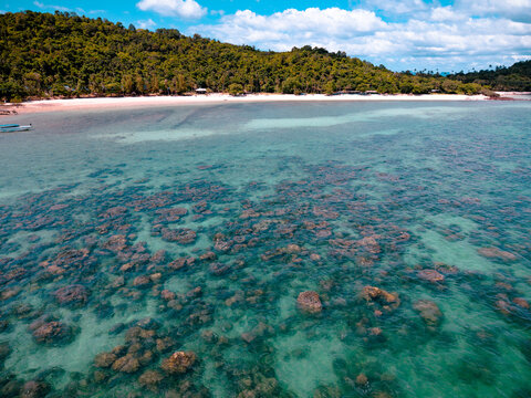 View of the beach and coastline of remote island along with underwater natural hard coral and reef