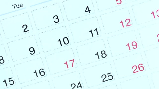 Calendar page turns showing month and year, close-up view of date grid