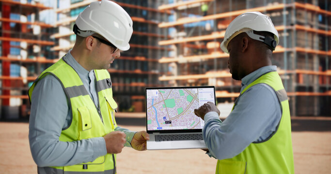 Civil Engineer And Contractor Review Land Survey Plans Together