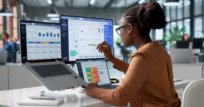 Insurance Underwriter Carefully Reviews Policy Data Using Laptop
