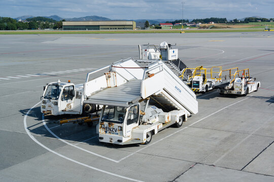 August 19, 2026, Stavanger, Norway - Airport ground support vehicles including passenger stairs and tugs on the tarmac