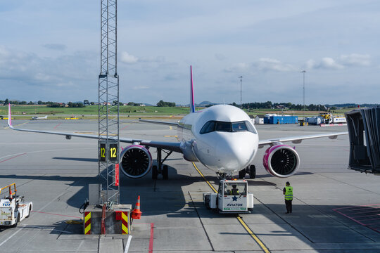 August 19, 2026, Stavanger, Norway - Wizz Air Airbus A320 aircraft parked at airport gate with ground crew and pushback tug