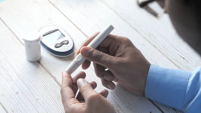 Person checking blood sugar levels with glucose meter and lancet device