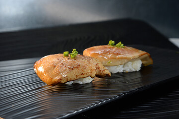 Seared Foie Gras Nigiri Sushi with Scallion Garnish on Black Plate © PhamThi