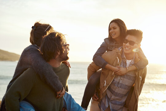 Happy, piggyback and travel with couple of friends by coast for sunset, holiday or reunion. People, playful and trip for bonding, fun and group with seaside get together or double date at beach