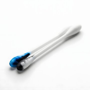 Two cotton swabs with colored tips one blue the other grey against a white background with soft lighting