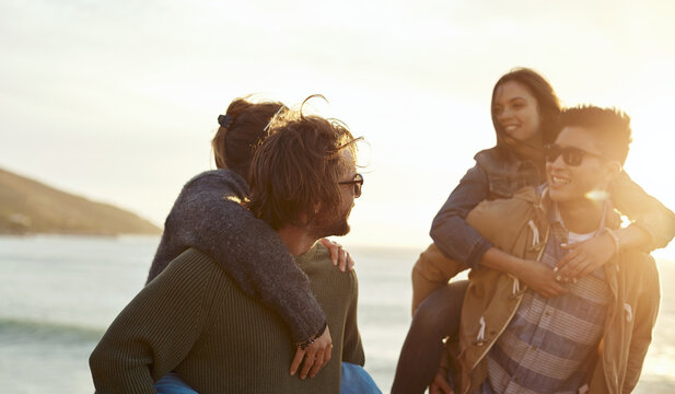 Smile, piggyback and travel with couple of friends by coast for sunset, holiday or reunion. People, playful and trip for bonding, fun and group with seaside get together or double date at beach