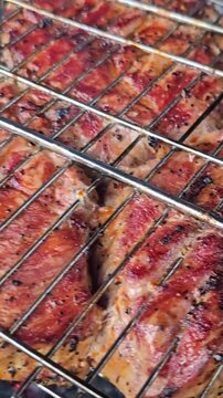 Grilling meat on a barbecue with smoke and heat in the background