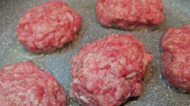 Cooking meat patties in a frying pan at home kitchen