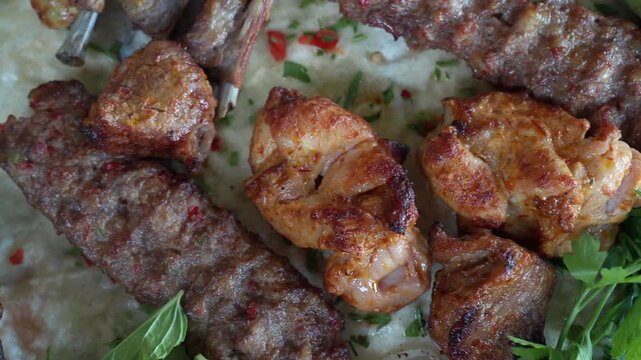 Turkish mixed kebab platter with grilled chicken and lamb kofta on flatbread with herbs and vegetables