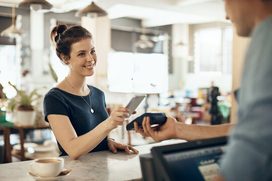 Phone, smile and payment with woman in cafe for fintech, pos machine and barista checkout. Customer experience, mobile transaction and digital banking with people in coffee shop for app and sale