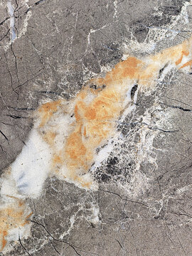 Abstract Gray Stone Texture with White and Orange Mineral Veins