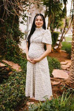 Smiling expectant mother holding her baby bump